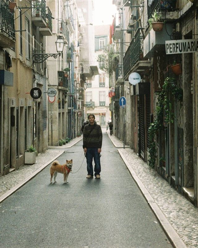 Diego Ramirez standing in a narrow old-town street with his dog on a lead.